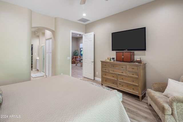 bedroom featuring arched walkways, a closet, light wood-type flooring, visible vents, and a ceiling fan