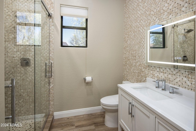 bathroom with baseboards, a shower stall, wood finished floors, and plenty of natural light