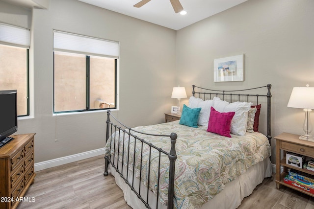 bedroom with wood finished floors, a ceiling fan, and baseboards