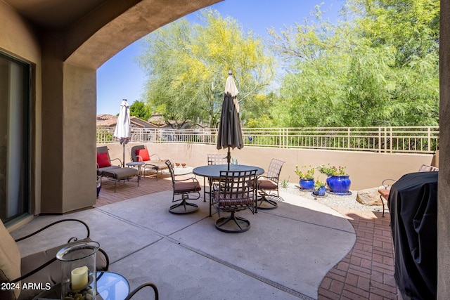 view of patio / terrace featuring a grill, fence, and outdoor dining area
