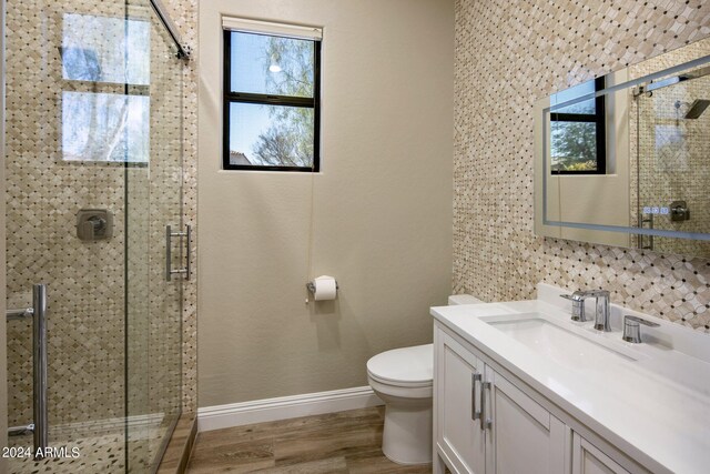 full bath featuring baseboards, wood finished floors, a shower stall, and plenty of natural light
