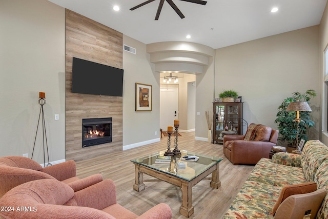living area featuring visible vents, light wood-type flooring, recessed lighting, a fireplace, and a ceiling fan