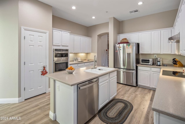 kitchen featuring exhaust hood, a sink, visible vents, white cabinets, and appliances with stainless steel finishes