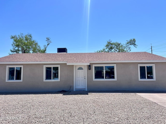 ranch-style house with a shingled roof and stucco siding
