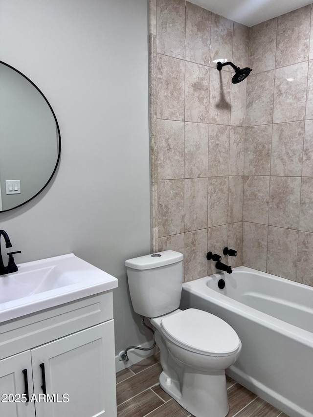 full bathroom featuring wood finished floors, toilet, bathtub / shower combination, and vanity