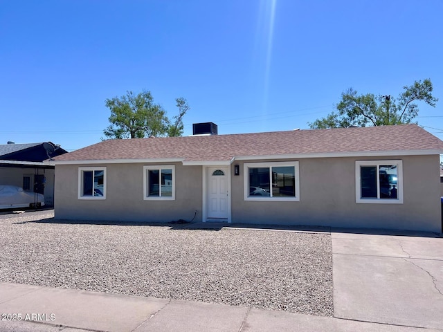 single story home featuring stucco siding, central AC, and a shingled roof