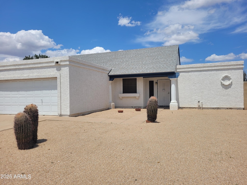 ranch-style home with stucco siding and a garage