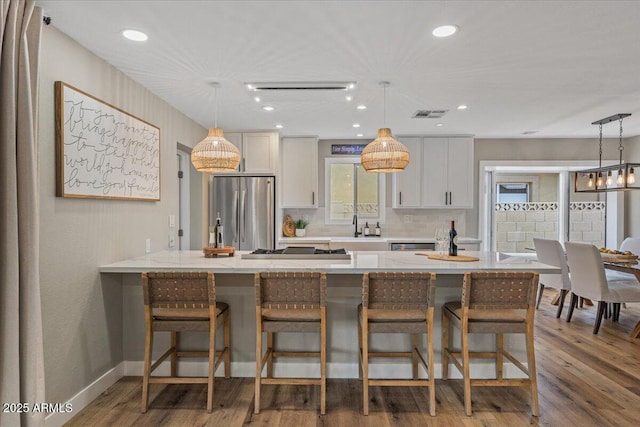 5332 N 81st Pl, Scottsdale, AZ 85250 - kitchen with stainless steel appliances, a breakfast bar area, decorative backsplash, wood finished floors, and recessed lighting