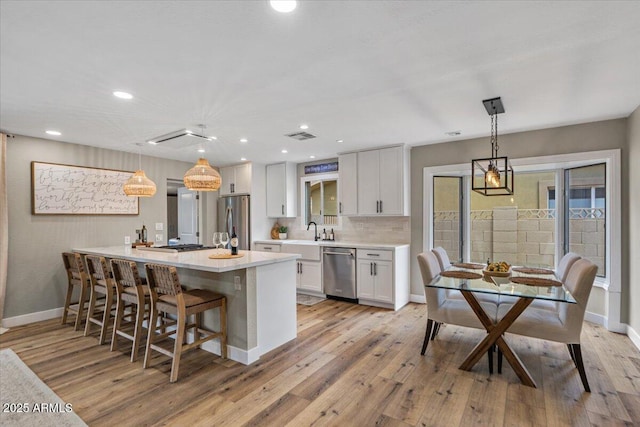 5332 N 81st Pl, Scottsdale, AZ 85250 - kitchen featuring stainless steel appliances, white cabinetry, light countertops, light wood-type flooring, and recessed lighting