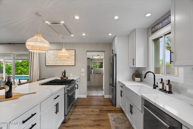 5332 N 81st Pl, Scottsdale, AZ 85250 - kitchen with appliances with stainless steel finishes, recessed lighting, light stone countertops, white cabinetry, and hanging light fixtures