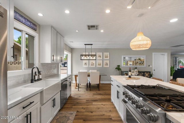 5332 N 81st Pl, Scottsdale, AZ 85250 - kitchen with stainless steel appliances, decorative backsplash, hanging light fixtures, recessed lighting, and light stone counters
