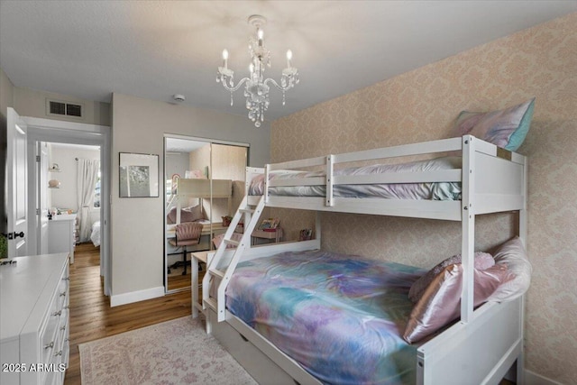 5332 N 81st Pl, Scottsdale, AZ 85250 - bedroom with wood finished floors, a chandelier, wallpapered walls, and a closet