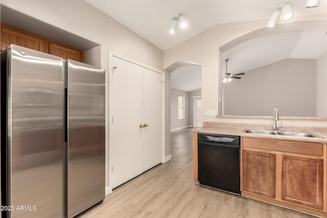10317 E Kiva Cir, Mesa, AZ 85209 - kitchen with arched walkways, black dishwasher, a sink, freestanding refrigerator, and vaulted ceiling