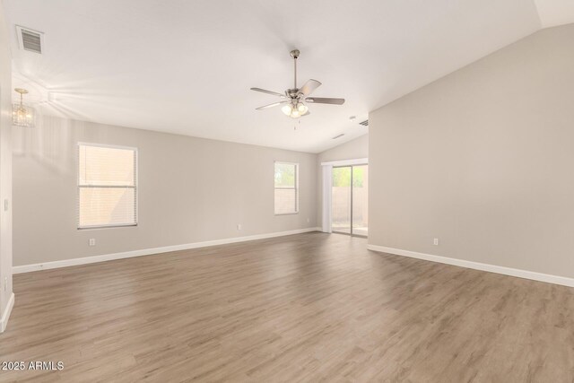 10317 E Kiva Cir, Mesa, AZ 85209 - spare room featuring baseboards, wood finished floors, vaulted ceiling, and ceiling fan with notable chandelier