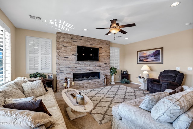 living room with ceiling fan and a fireplace