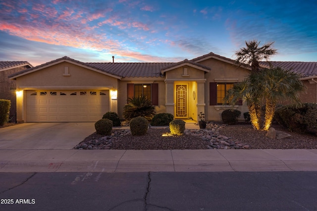 ranch-style house with concrete driveway, an attached garage, a tiled roof, and stucco siding