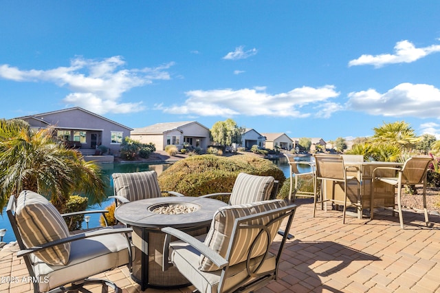 view of patio / terrace featuring an outdoor fire pit and a water view