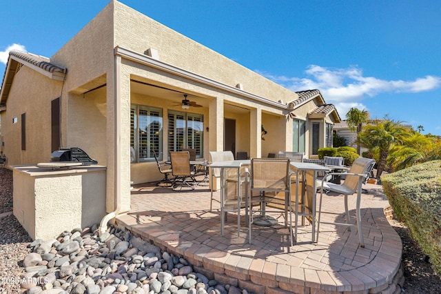 view of patio featuring exterior kitchen and ceiling fan