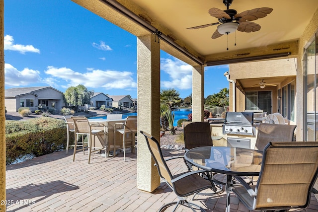 view of patio with a pool, a water view, area for grilling, and ceiling fan