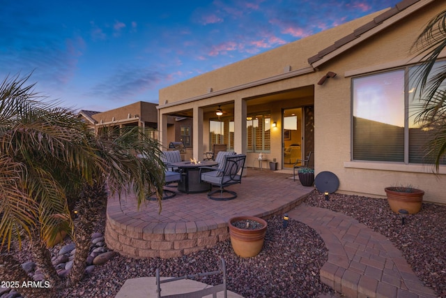 patio terrace at dusk featuring an outdoor fire pit