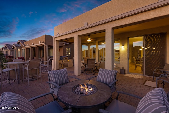 patio terrace at dusk featuring an outdoor fire pit and outdoor dining space