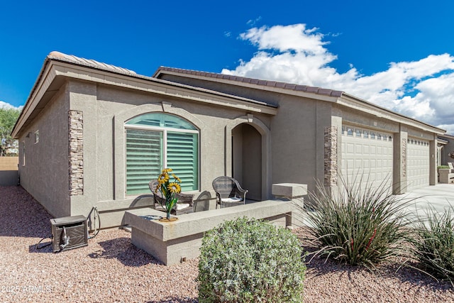 view of front of property featuring an attached garage and stucco siding