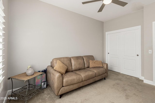 living area with a ceiling fan, carpet, and baseboards