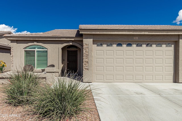 view of front of house featuring driveway, an attached garage, and stucco siding