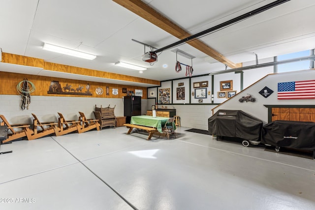 garage featuring black refrigerator and a garage door opener