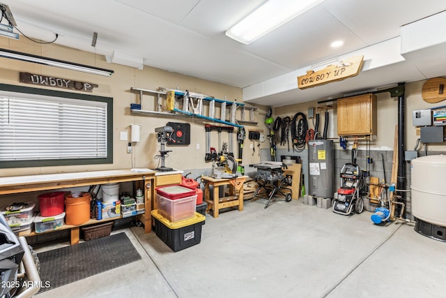 garage with electric water heater and a workshop area