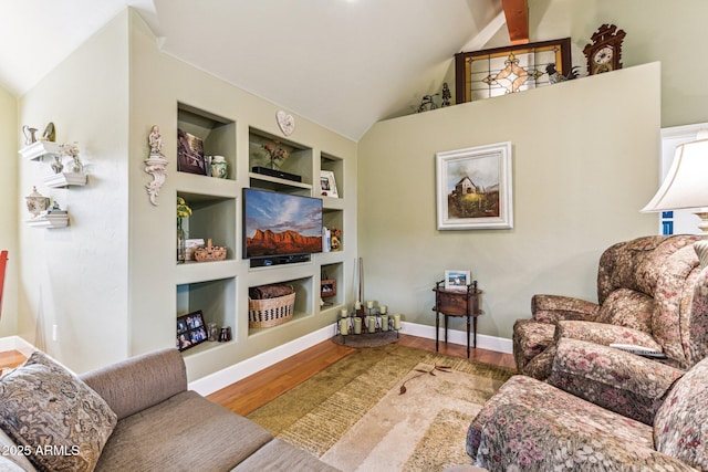 living room featuring wood-type flooring, vaulted ceiling with beams, and built in shelves