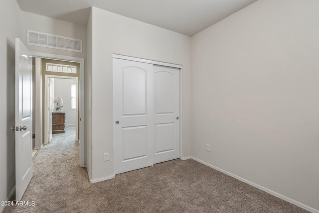 unfurnished bedroom featuring a closet and carpet flooring