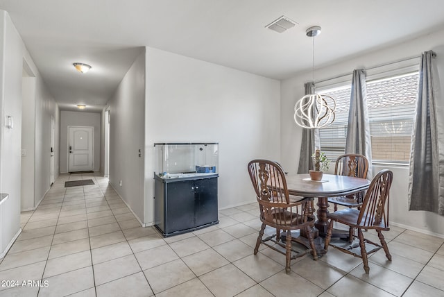 tiled dining area featuring a chandelier