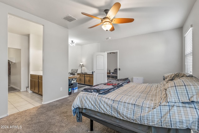 bedroom featuring ceiling fan, light colored carpet, and ensuite bathroom