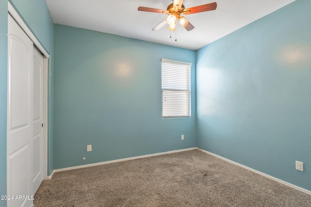 unfurnished bedroom with carpet flooring, ceiling fan, and a closet