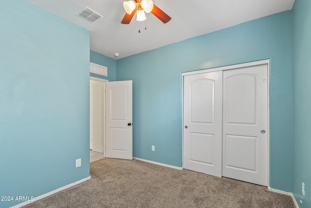 unfurnished bedroom featuring light carpet, ceiling fan, and a closet