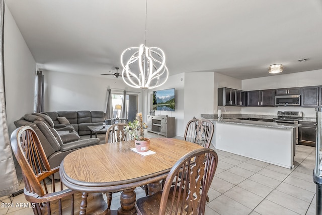 tiled dining room with ceiling fan with notable chandelier and sink