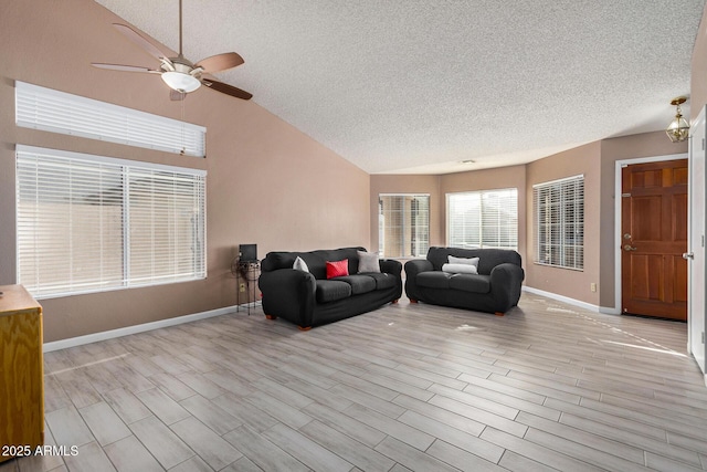 living room with ceiling fan, vaulted ceiling, and a textured ceiling