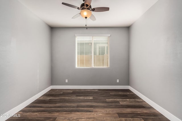 spare room featuring baseboards, wood finished floors, and a ceiling fan