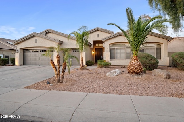 mediterranean / spanish-style house with stucco siding, driveway, and an attached garage