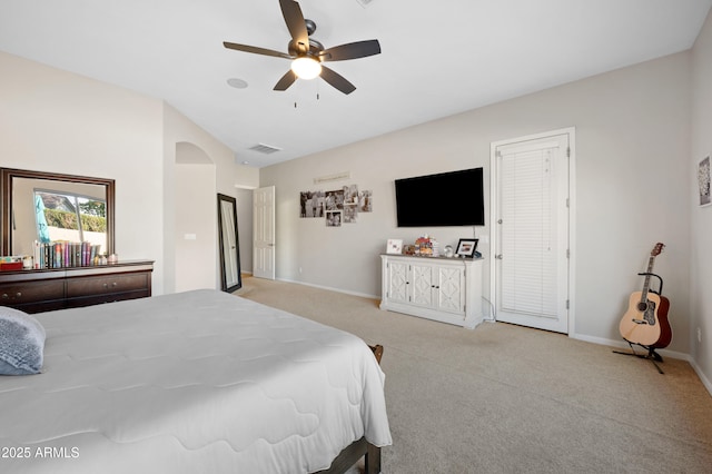 bedroom with visible vents, baseboards, arched walkways, ceiling fan, and light colored carpet