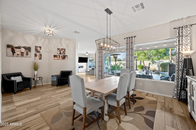 dining space featuring light wood-type flooring, visible vents, and baseboards