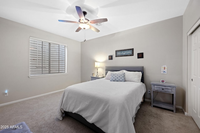 carpeted bedroom featuring a closet, baseboards, and a ceiling fan