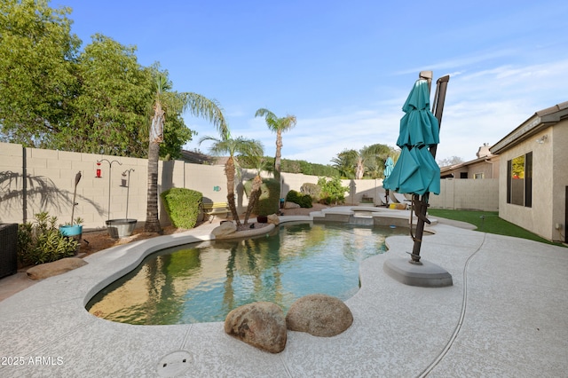 view of pool featuring a patio area, a pool with connected hot tub, and a fenced backyard