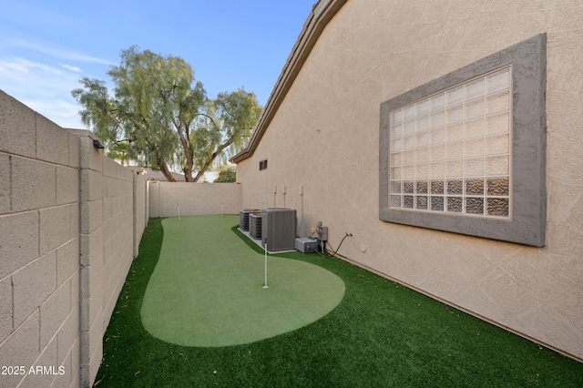 view of yard with central AC unit and a fenced backyard