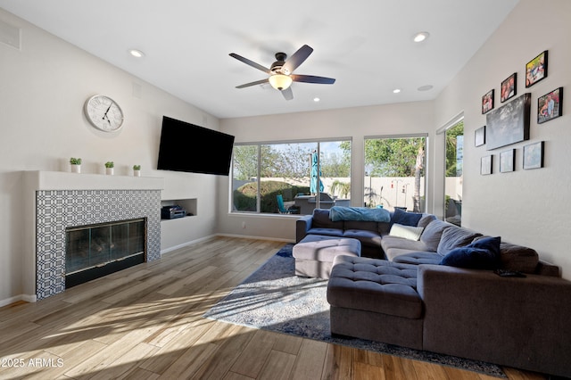 living room featuring wood finished floors, recessed lighting, a fireplace, and baseboards