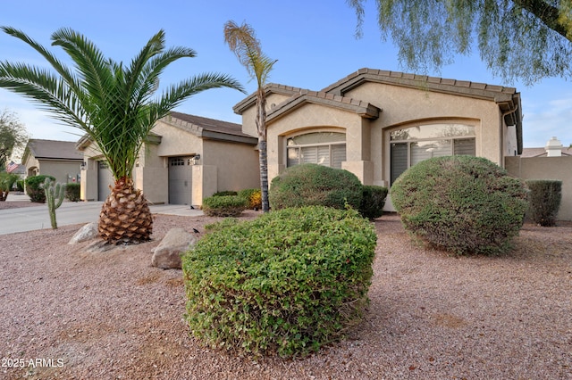 view of front of house featuring stucco siding, concrete driveway, and an attached garage