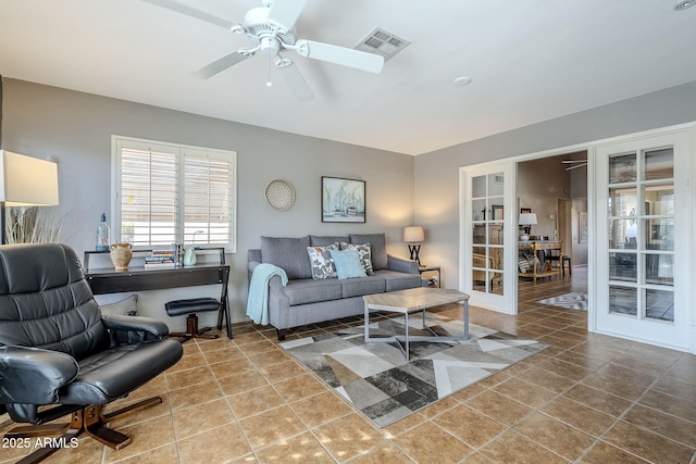 tiled living room with french doors and ceiling fan