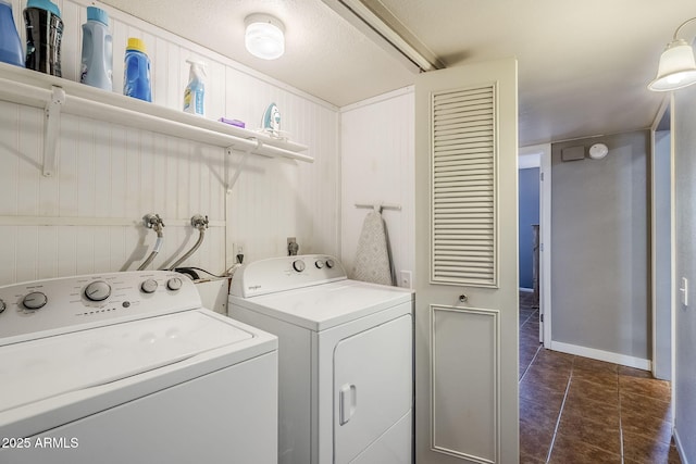 laundry room with dark tile patterned flooring and washing machine and clothes dryer