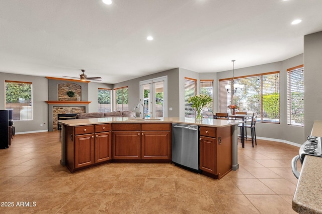 kitchen featuring pendant lighting, stainless steel dishwasher, a center island with sink, and sink